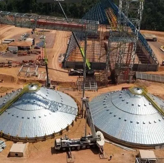 Vista aérea do terminal em obra, com dois armazéns em cúpula e estruturas metálicas